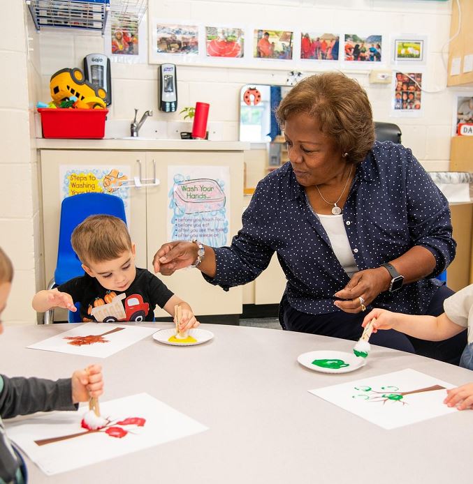 Congressional School toddler painting with their teacher